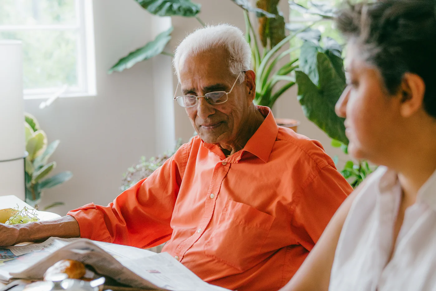 Un senior et une aidante relisent des documents ensemble