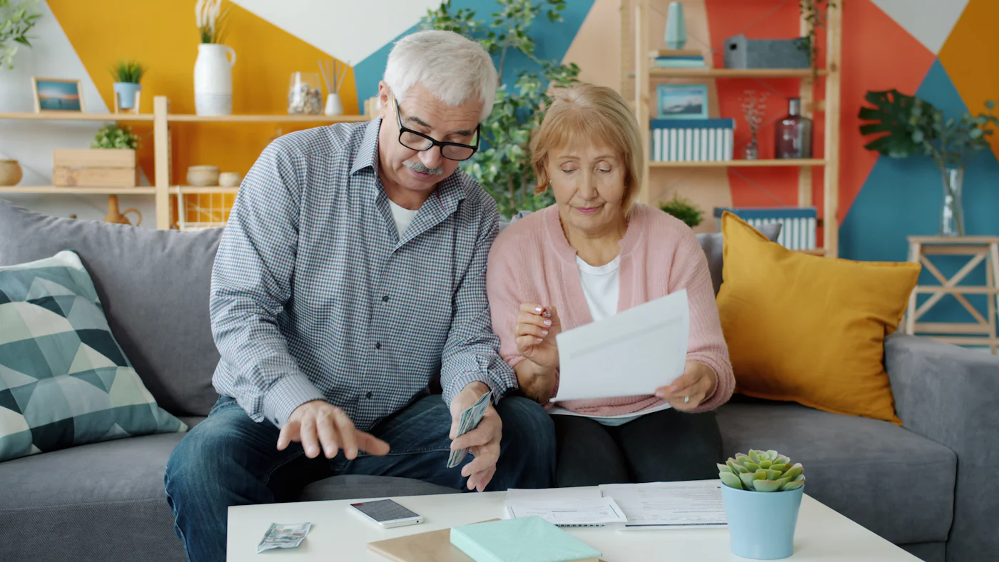 Un couple de seniors consulte ses documents à domicile