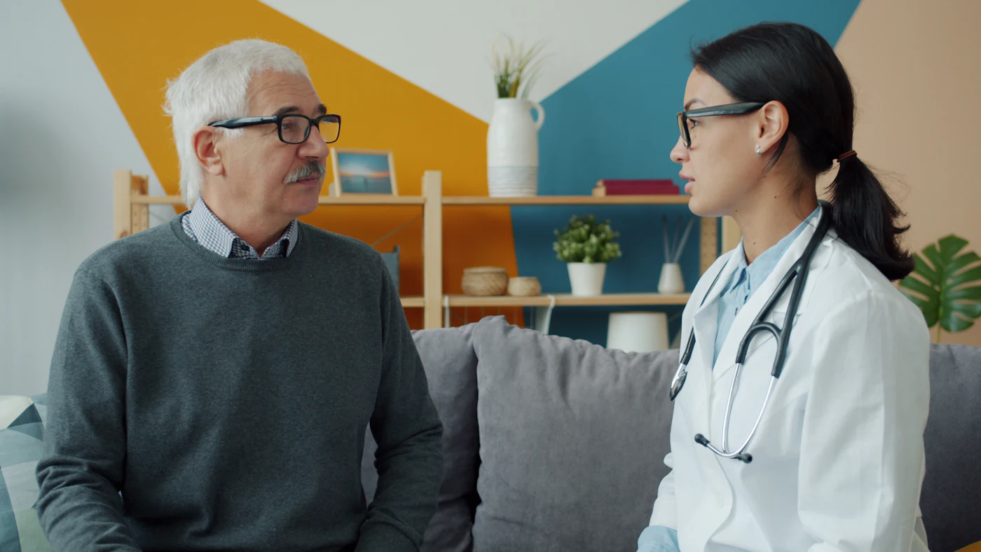 Une médecin en visite chez un patient âgé